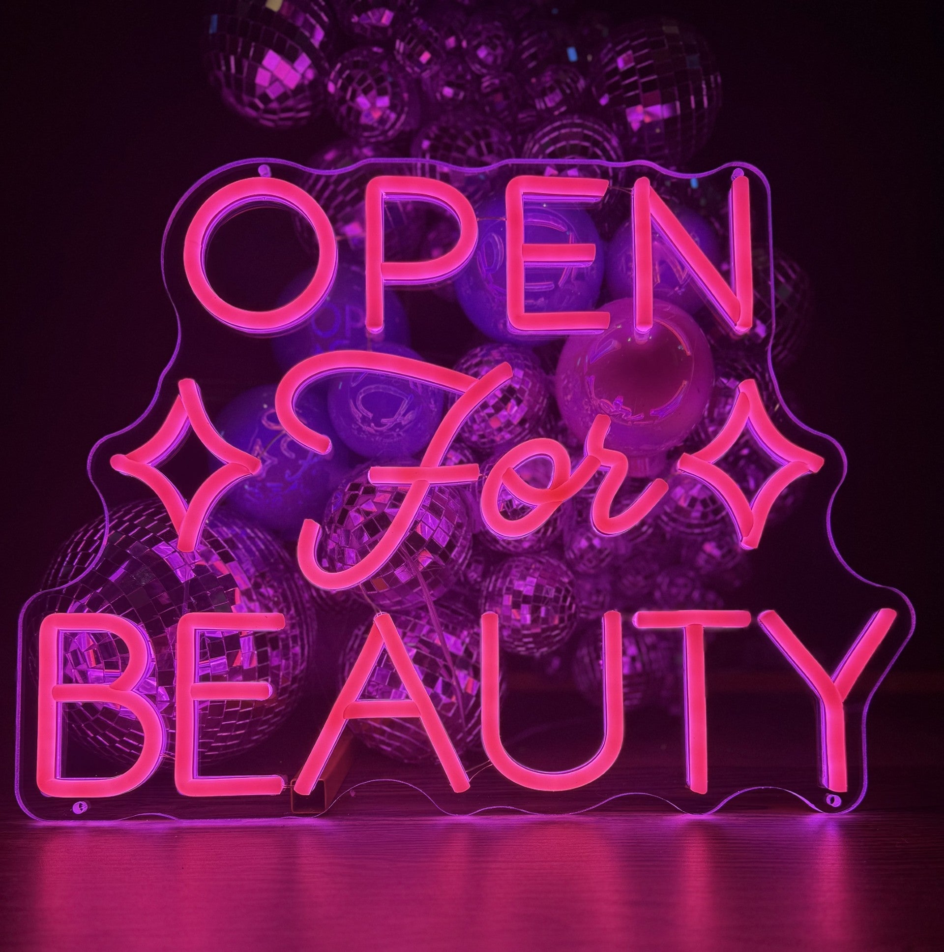 A pink LED neon sign displaying "OPEN for BEAUTY" in a mix of block and script lettering, mounted on a clear, contour-cut acrylic backing.